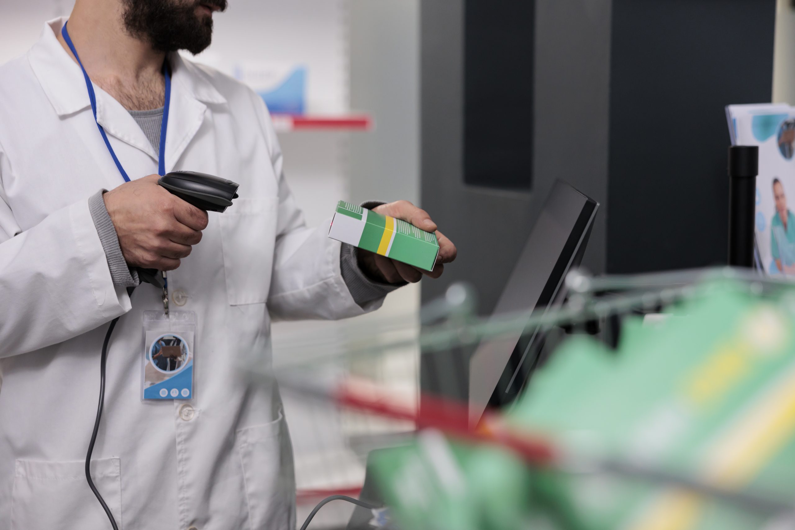 Man pharmacist holding store scanner that reads the barcodes on all the drugs and packages